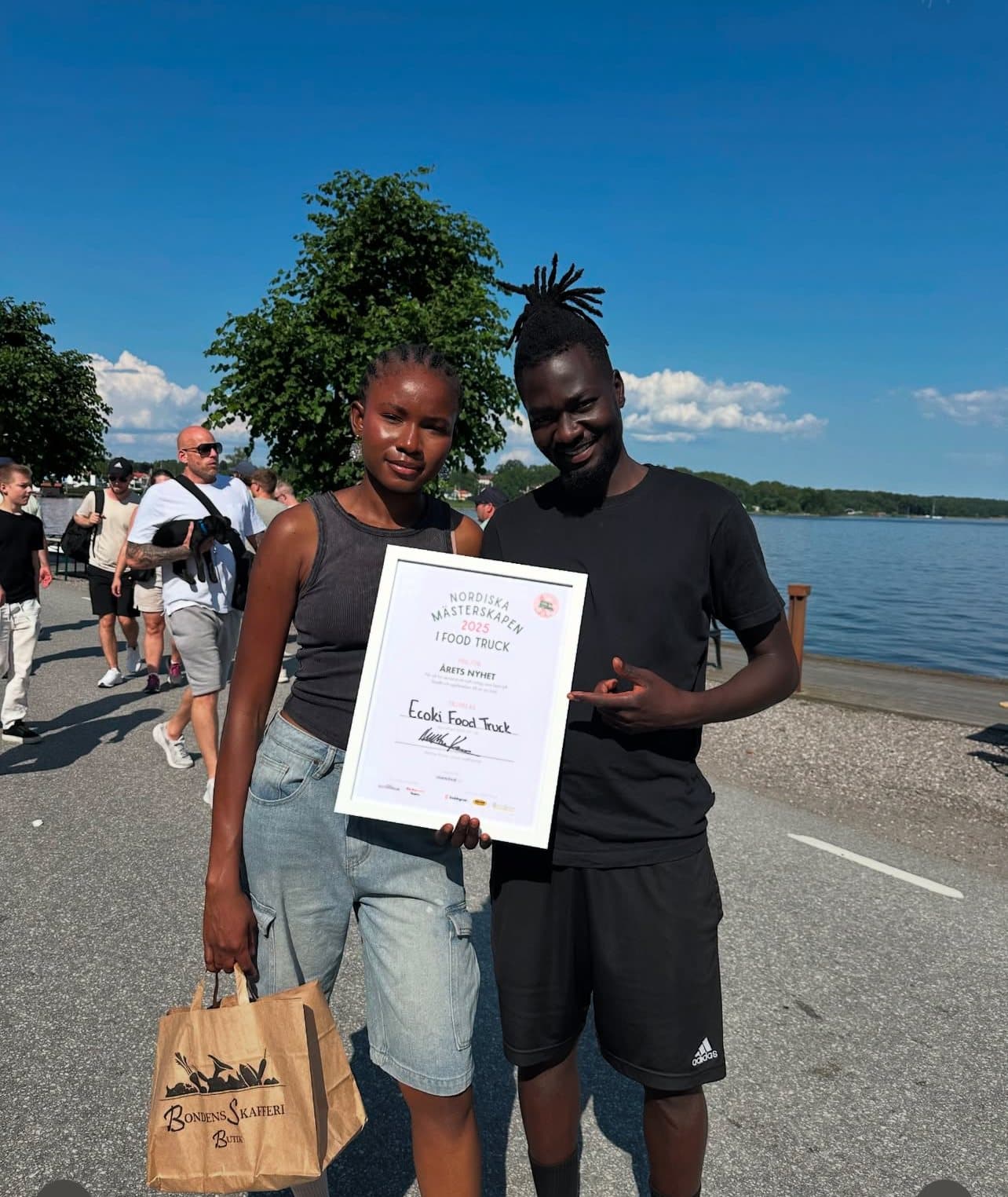 Two of the Igbokwe siblings by the water with their award certificate