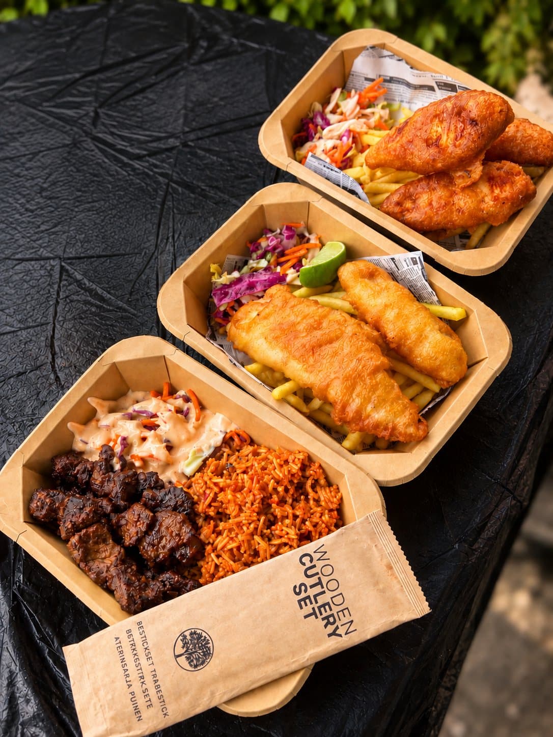Take away-lådor med jollof, friterad fisk och suyabiff
